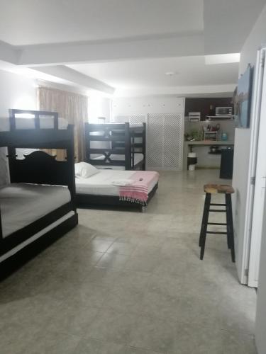 a room with three bunk beds and a stool at Aptos Miss Ada in San Andrés