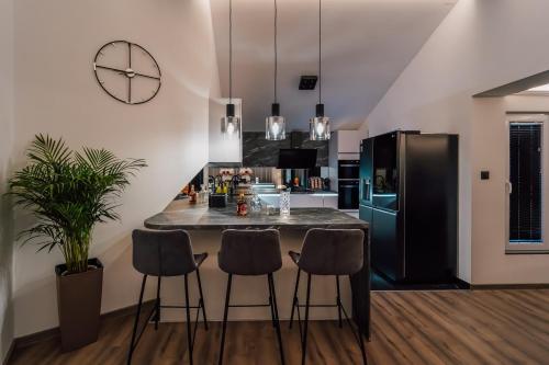 a kitchen with a counter with stools and a refrigerator at Luxury home apartment Las Palmas in Zadar