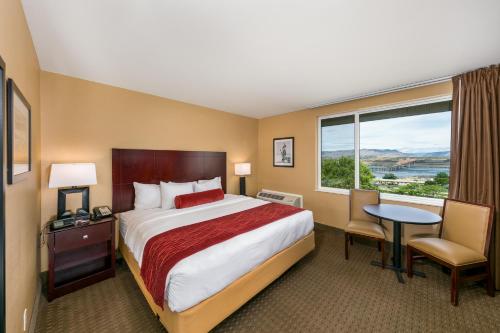 a hotel room with a bed and a large window at Celilo Inn in The Dalles