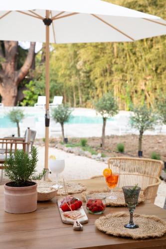 a wooden table with food and an umbrella at La Bâtisse en Blanc in Golfe-Juan