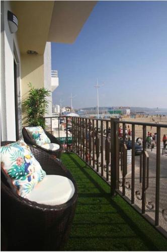 a balcony with chairs and a view of the beach at Flipflops Ocean View in Nazaré