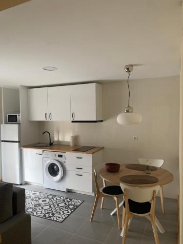 uma cozinha com uma mesa e uma cozinha com uma máquina de lavar roupa em Casa Cristina - Rioja - I em Cenicero