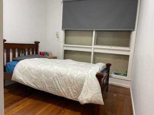a bedroom with a bed and a large window at D High quality large bed rooms near commercial areas, universities, and rail transit in villas in Melbourne