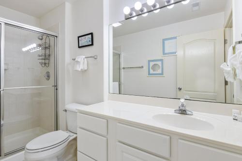 a bathroom with a sink and a toilet and a mirror at On a Point in Lake Ozark