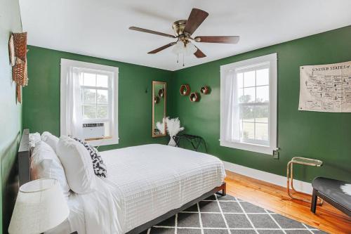 Schlafzimmer mit grünen Wänden und einem Bett mit Deckenventilator in der Unterkunft Mountain View Farmhouse in Luray, Family Friendly in Luray