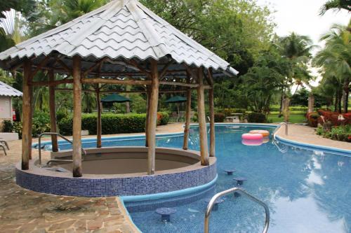 a pool with a gazebo next to a swimming pool at Tropical Bliss Pool Wi-Fi BBQ Near Quepos Manuel Antonio in Quepos