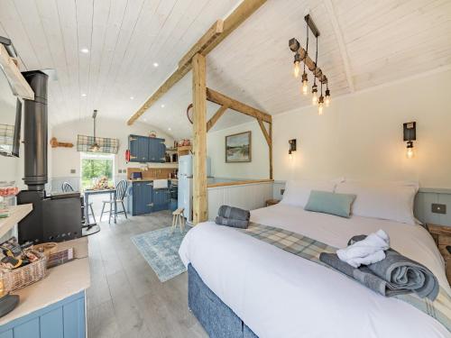 um quarto com uma cama grande e uma cozinha em The Liddel Dutch Barn - Uk44465 em Saughtree