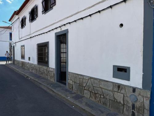 a white building with a door on the side of a street at Casa da Avó Albertina in Mourão