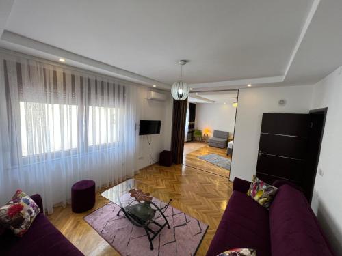 a living room with a purple couch and a table at Zani Boutique Hotel in Prizren