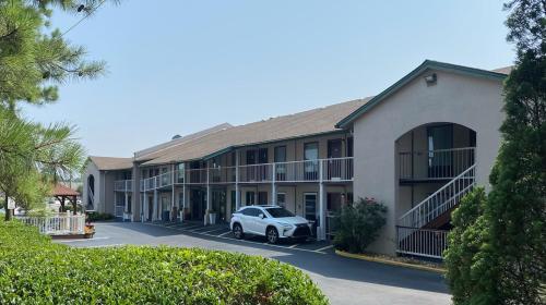 a building with a car parked in a parking lot at West Bank Inn in Augusta