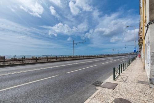an empty highway with street lights on the side of a building at A Casa do Jamor in Cruz Quebrada
