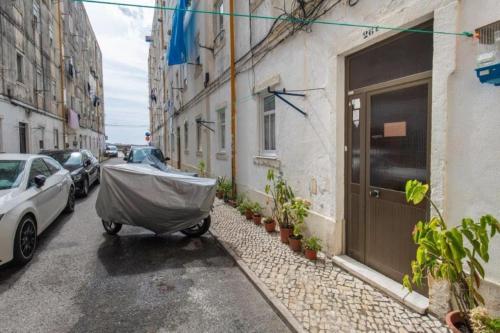 a cart parked on a street next to a building at A Casa do Jamor in Cruz Quebrada
