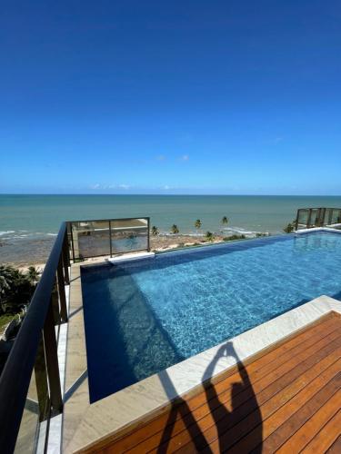 a swimming pool with a view of the beach at Apartamento Praia de Carapibus in Conde