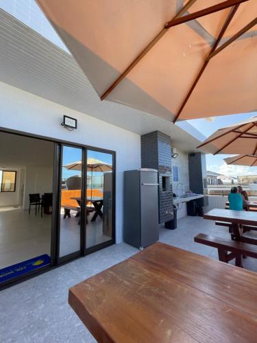 ein Esszimmer mit einem Tisch und eine Küche mit einer offenen Decke in der Unterkunft Apartamento Praia de Carapibus in Conde
