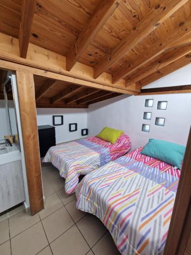 two beds in a room with wooden ceilings at Casa Nido in Icod de los Vinos