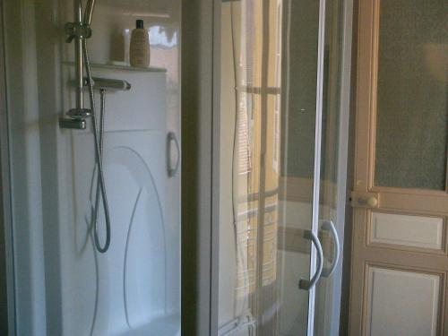 La salle de bains est pourvue d'une douche et d'un réfrigérateur blanc. dans l'établissement Chambre d'hôte d'une maison de chanoine - pas un hôtel, 2e étage, 3 pièces 90m2, à Autun