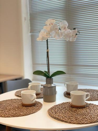 a table with a vase with white flowers on it at King's Cross in London