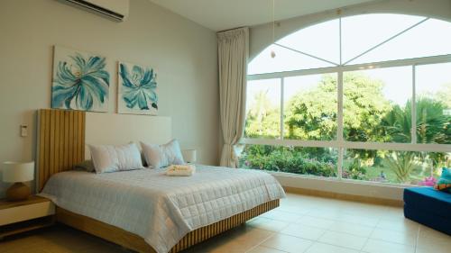 um quarto com uma cama e uma grande janela em Amazing Beachfront Villa - Palm House em Punta Chame