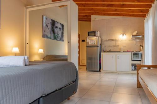 a bedroom with a large bed and a kitchen at Los Amancays 2 in Villa La Angostura