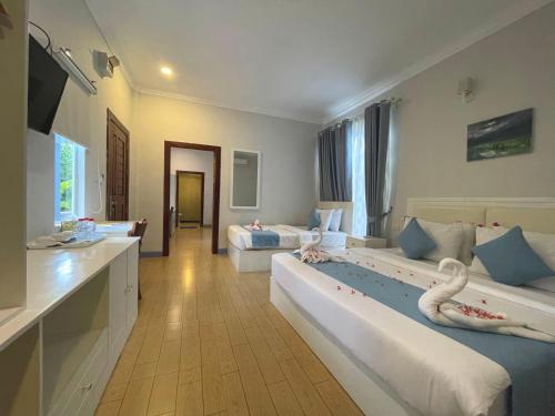 Una habitación de hotel con dos camas con cisnes. en SCARLET SAILS BUNGALOW en Koh Rong Island