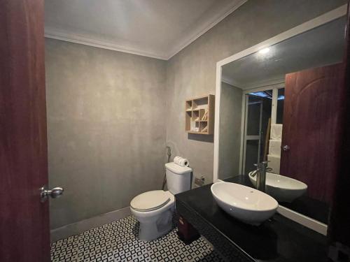 a bathroom with a white toilet and a sink at SCARLET SAILS BUNGALOW in Koh Rong Island