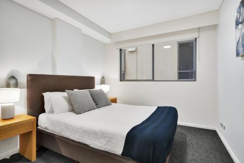 Un dormitorio con una cama grande y una ventana en Corporate Apartment North Sydney MIL2251306 en Sídney