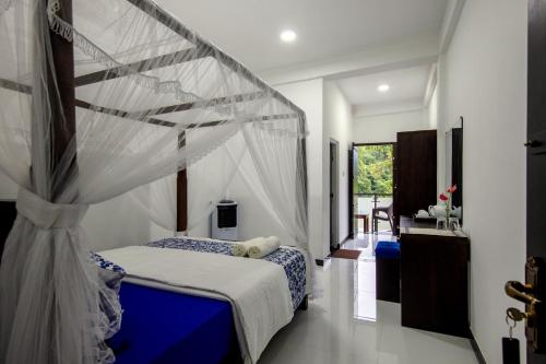 a bedroom with a bed with a mosquito net at Jeans Holiday Resort in Kandy