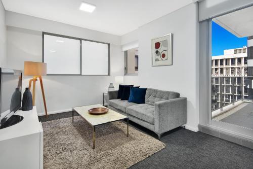 a living room with a couch and a table at North Sydney Corporate Apartment MIL2251106 in Sydney