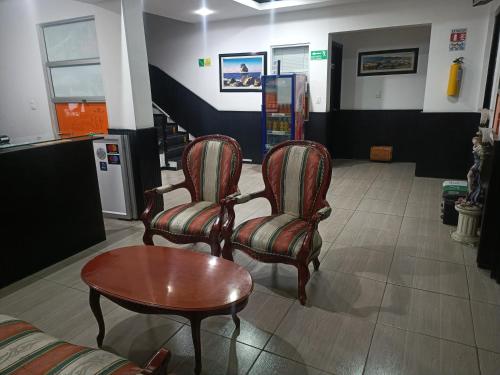 a waiting room with two chairs and a table at Hotel Bariloche Confort in Pasto