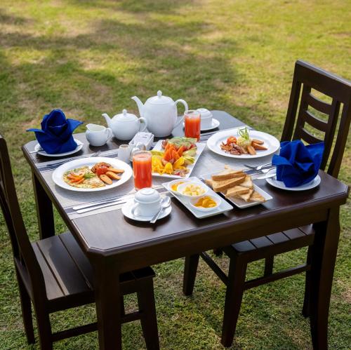 un tavolo con piatti di cibo e una teiera di Jeans Holiday Resort a Kandy