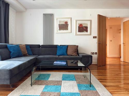 a living room with a couch and a glass coffee table at Canary Wharf - Luxury Apartments in London