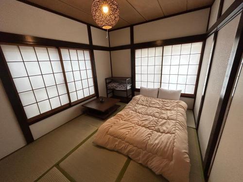 1 dormitorio con 1 cama en una habitación con ventanas en 1970's Japanese style dorm house, en Tokio