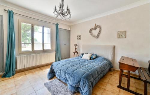 a bedroom with a bed and a table and a window at Stunning Home In Vallabrgues With Kitchen in Vallabrègues