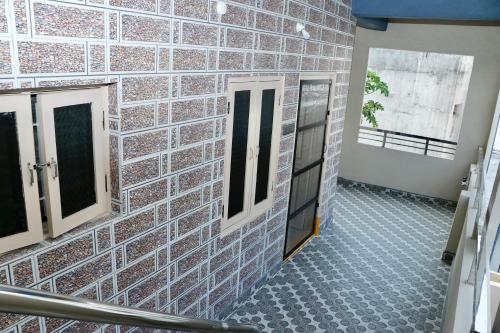 a bathroom with a brick wall and two windows at V Homestays in Bhadrāchalam