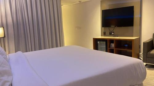 Habitación de hotel con cama y TV de pantalla plana. en Apartamento em Frente ao Mar, en Río de Janeiro