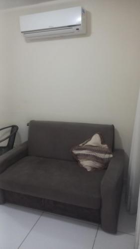 a brown couch sitting in a room with a light at Israel Flat Tambaú - 213 in João Pessoa