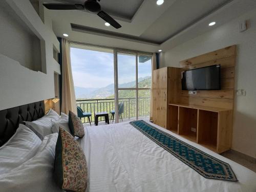 a bedroom with a bed with a television and a balcony at Nature Heaven Lodge, Mussoorie in Mussoorie