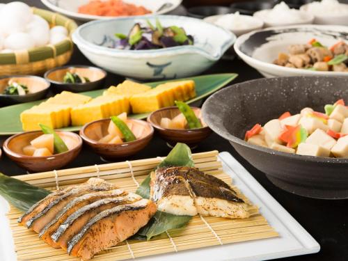 a table topped with plates of food and bowls of food at The Park Front Hotel at Universal Studios Japan in Osaka