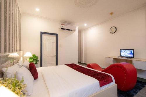 a hotel room with a bed and a red chair at Ben Thanh Station Hotel in Ho Chi Minh City