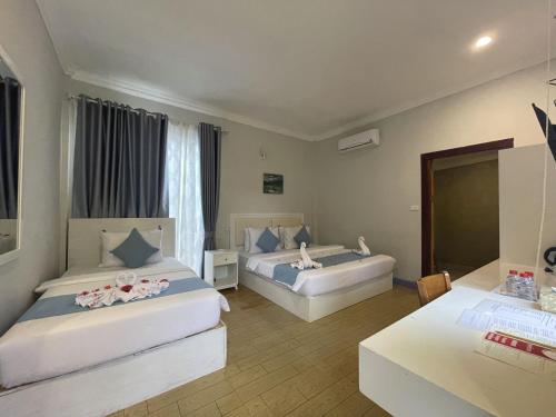a hotel room with two beds and a desk at Scarlet Sails Resort in Koh Rong Island