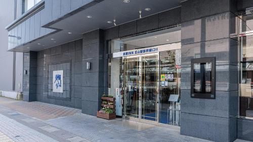 una tienda frente a un edificio con puertas de cristal en Toyoko Inn Toyama-eki Shinkansen-guchi No.2, en Toyama