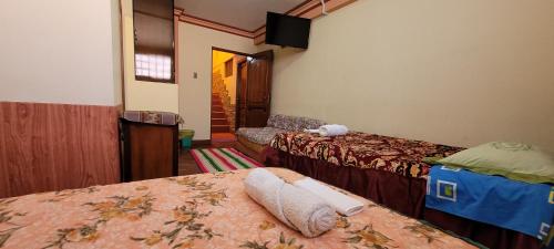 Habitación de hotel con 2 camas y TV en Hostal Sol y Luna en Copacabana