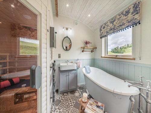 a bathroom with a tub and a sink at The Liddel Dutch Barn - Uk44465 in Saughtree