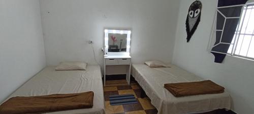 2 Betten in einem kleinen Zimmer mit Spiegel in der Unterkunft Hostal Casa Azul, doble in Orizaba