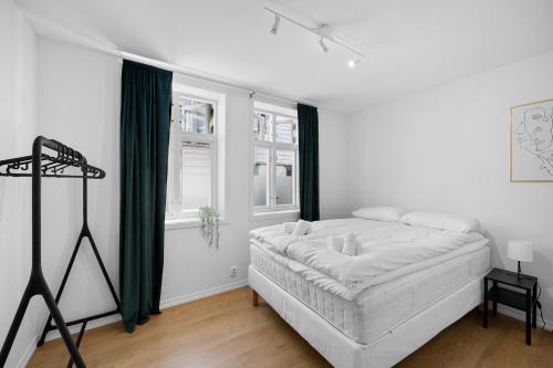 a white bedroom with a bed and a window at 5min to Bryggen - Renovated - Budget friendly in Bergen