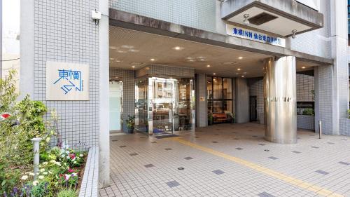una entrada a un edificio con un cartel en él en Toyoko Inn Sendai Higashi-guchi No 2 en Sendai