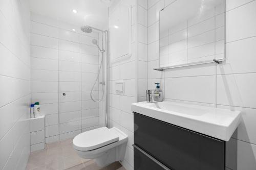 Baño blanco con aseo y lavamanos en 5min to Bryggen - Renovated - Budget friendly, en Bergen