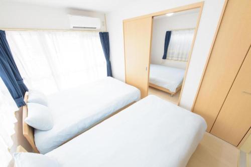 a small room with a bed and a mirror at COCOSTAY Felice ココステイ フェリーチェ in Hiroshima