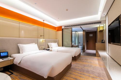 a hotel room with two beds and a television at Landmark International Hotel in Guangzhou