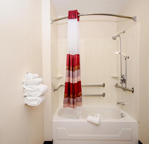a bathroom with a tub and a shower with towels at Red Roof Inn Philadelphia - Oxford Valley in Langhorne